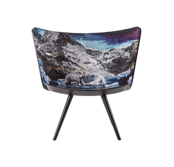 "Artistic lounge chair with curved wooden shell and scenic cross‑stitch embroidery, combining Scandinavian style and Italian craftsmanship."