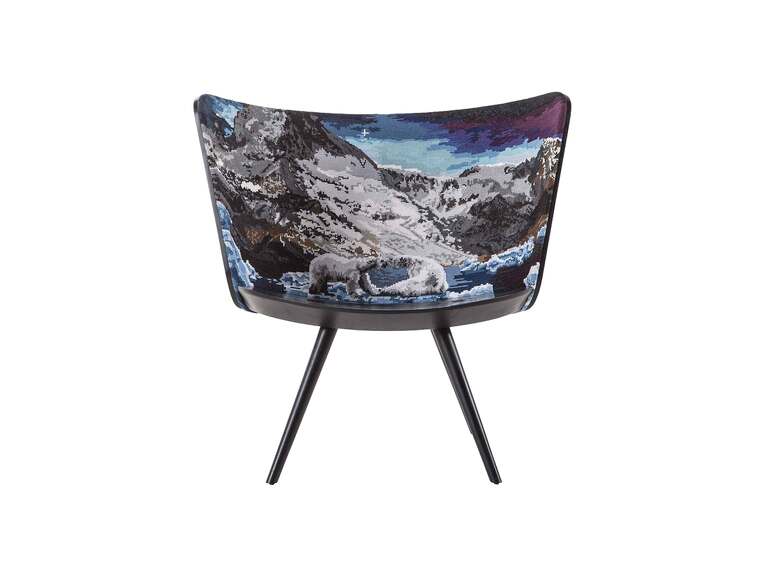 "Artistic lounge chair with curved wooden shell and scenic cross‑stitch embroidery, combining Scandinavian style and Italian craftsmanship."