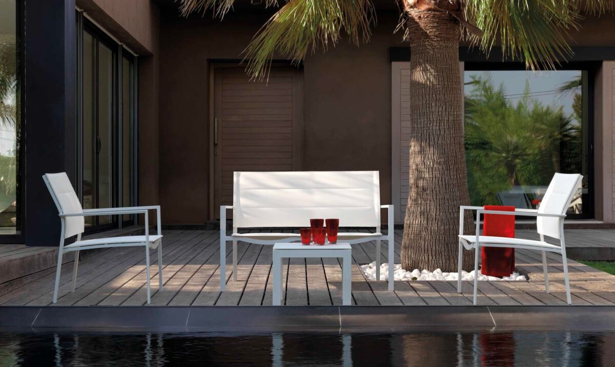 Minimalist Talenti Touch Pouf serving as a footrest or seat in a contemporary patio setting