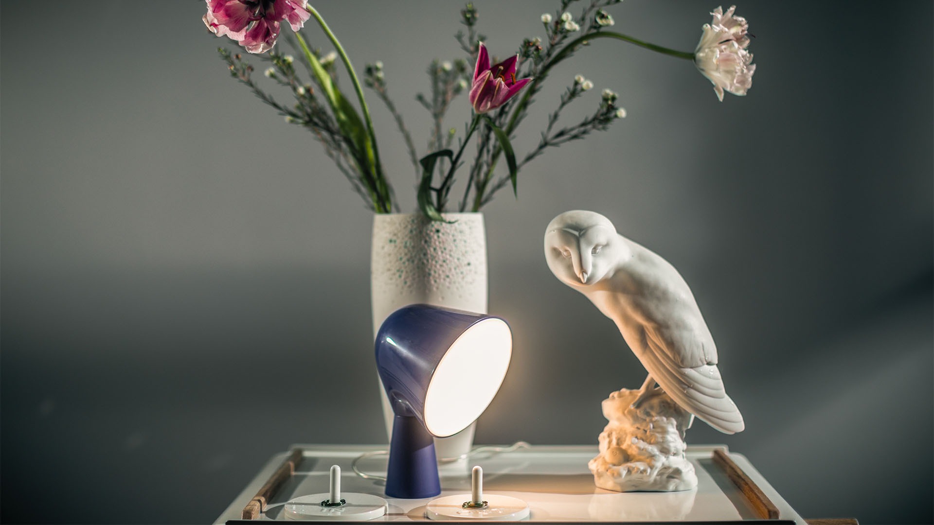Binic table lamp by Foscarini in aquamarine, showcasing playful design and soft downward light.