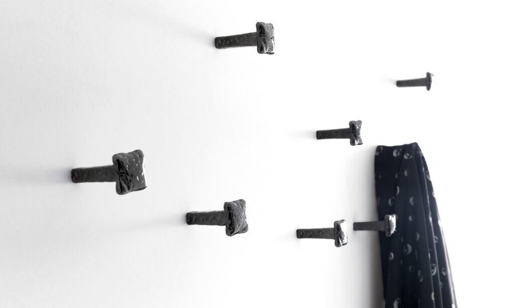 Chiodo Schiaccia Chiodo Nail by Opinion Ciatti in black nickel finish, wall-mounted minimalist coat hook, displayed in Royal Oak, Michigan.