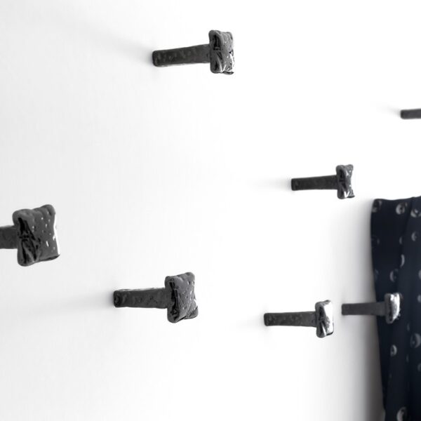 Chiodo Schiaccia Chiodo Nail by Opinion Ciatti in black nickel finish, wall-mounted minimalist coat hook, displayed in Royal Oak, Michigan.