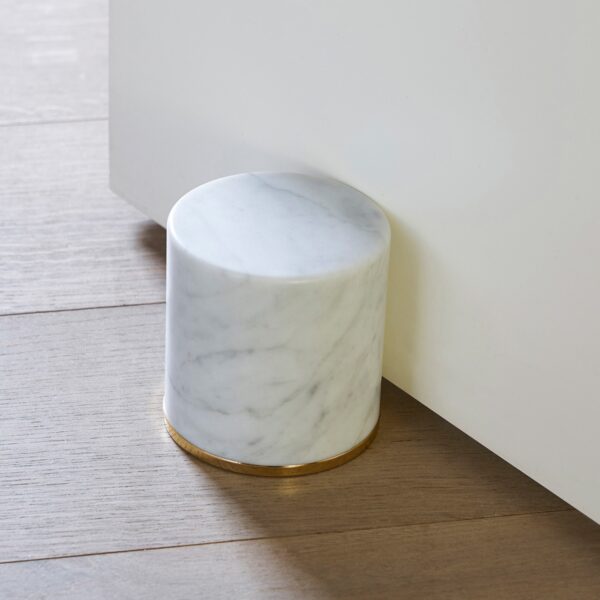 Fermaporte by Opinion Ciatti, a cylindrical white Carrara marble doorstop with a 24K gold-plated steel ring, adds a touch of luxury to contemporary interiors in Royal Oak, Michigan.
