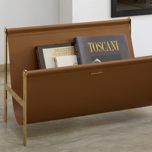 Portariviste magazine rack by Opinion Ciatti in natural leather with 24K gold frame, elegantly displaying magazines in a stylish living room setting.