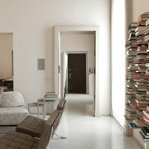 Ptolomeo Wall vertical wall-mounted bookcase by Opinion Ciatti in matte black steel, featuring C-shaped shelves that appear to levitate books, displayed in Royal Oak, Michigan showroom.