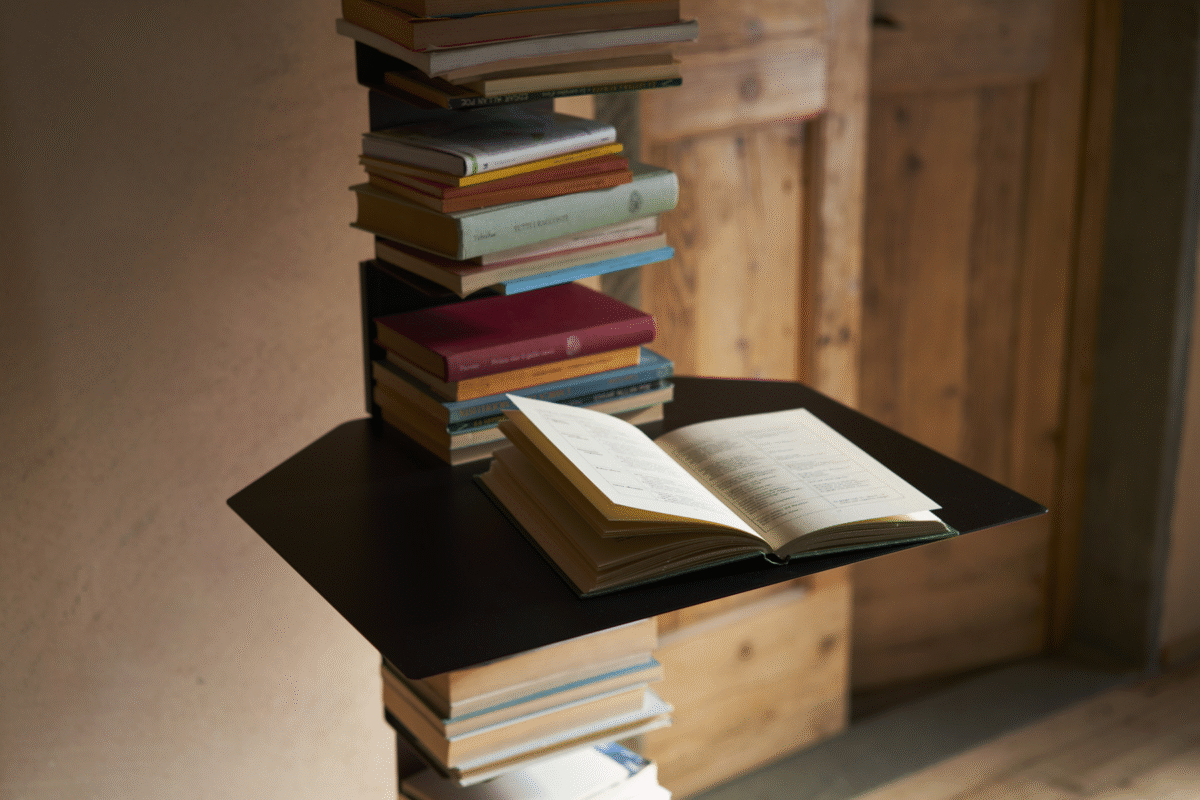 Ptolomeo Shelf by Opinion Ciatti in glossy white finish, seamlessly integrated between Ptolomeo bookcase shelves, serving as a compact writing desk or bedside table, displayed in Royal Oak, Michigan showroom.