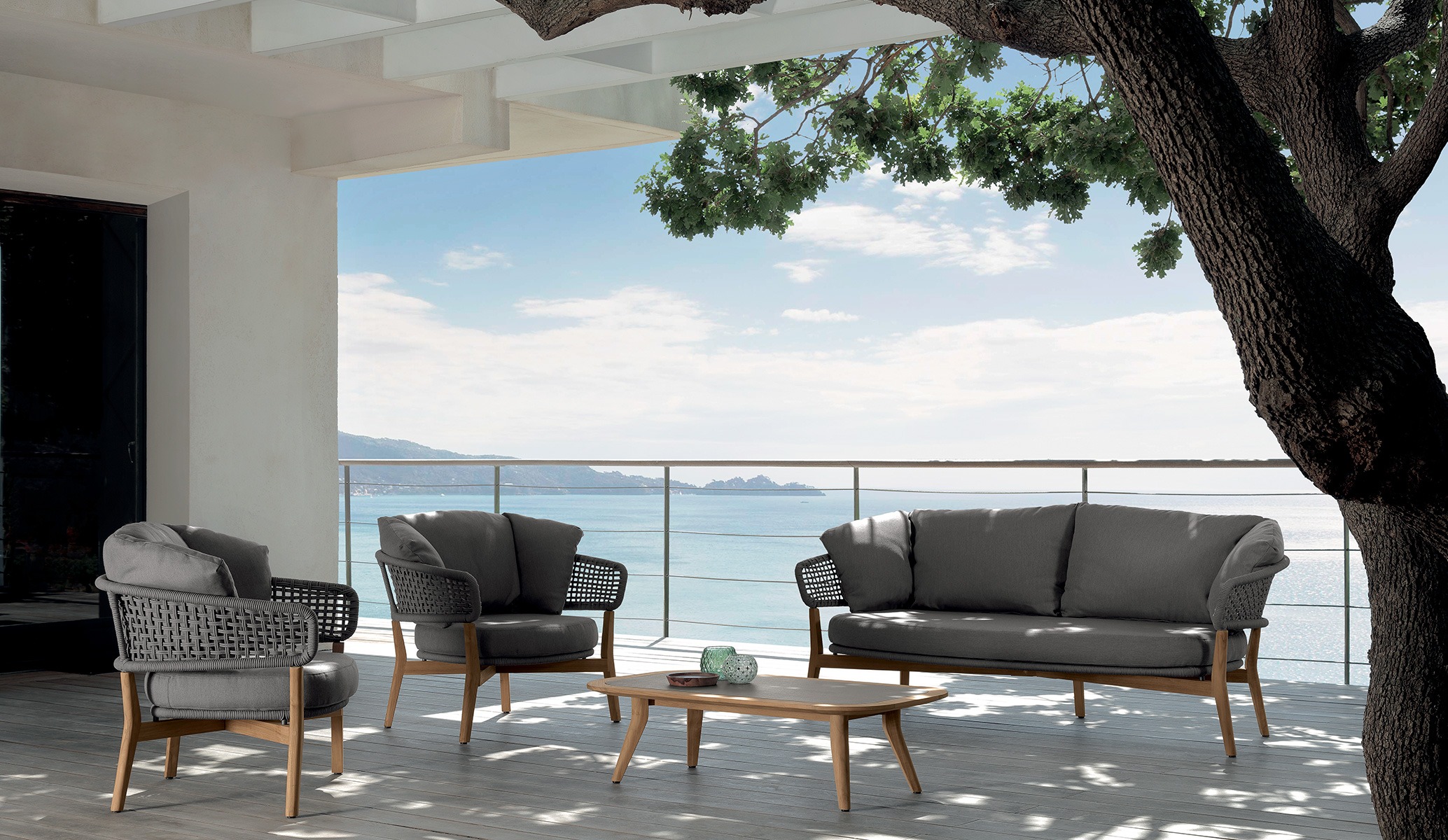 Moon//Teak Two-seater Sofa by Talenti, featuring a natural teak wood frame with intricate rope detailing for a modern outdoor look.