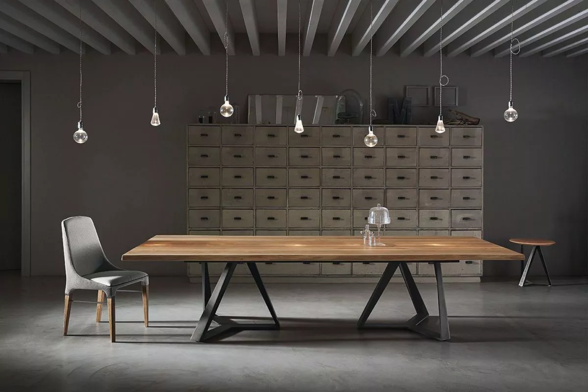 Close‑up of Millennium XXL by Bontempi highlighting joined X‑frame metal bases and smoked-grey extra-clear glass top.