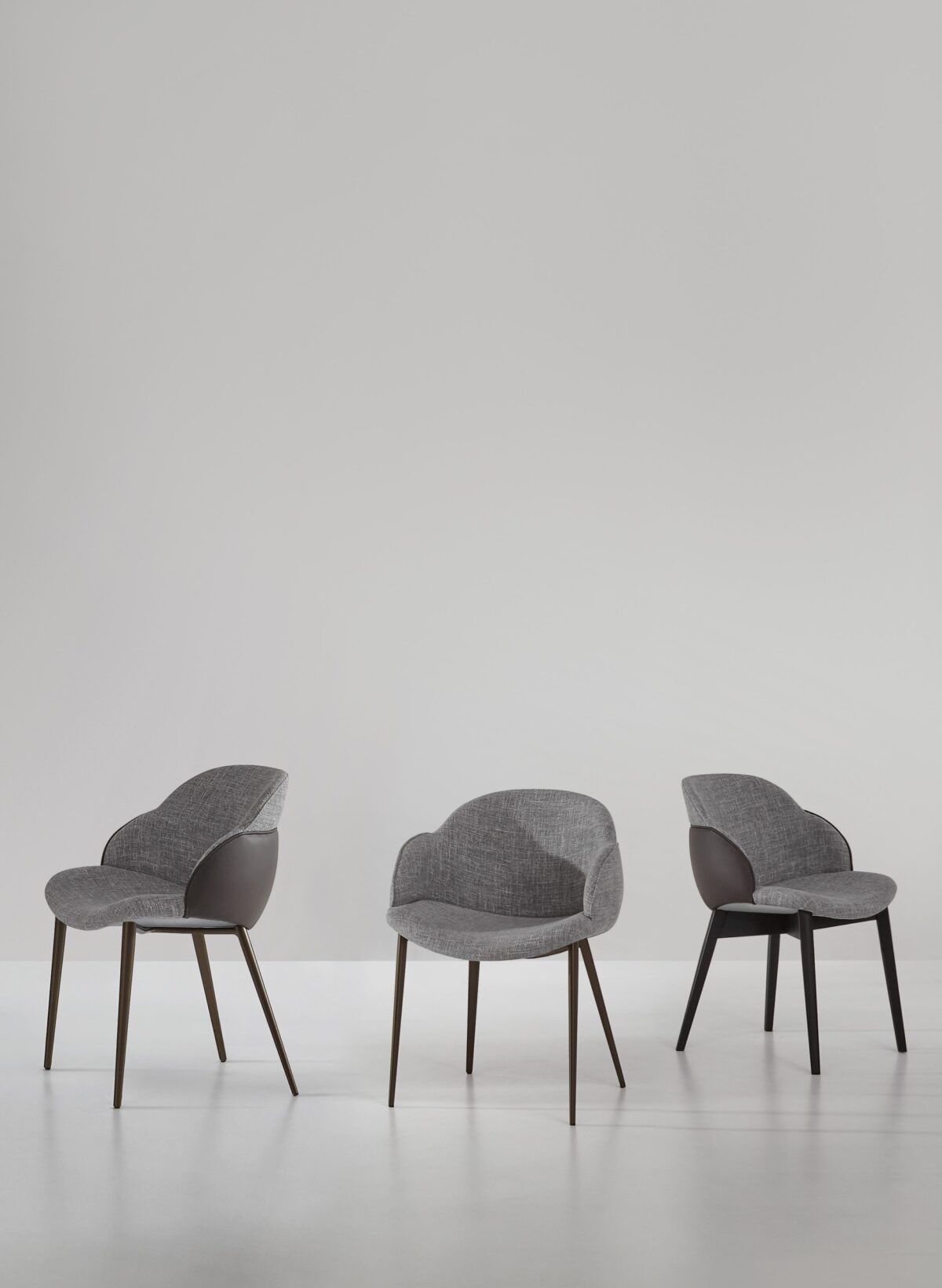 “Miss My Way chair by Bonaldo with enveloping high backrest, fabric interior and leather shell exterior supported by slender bronze legs.”