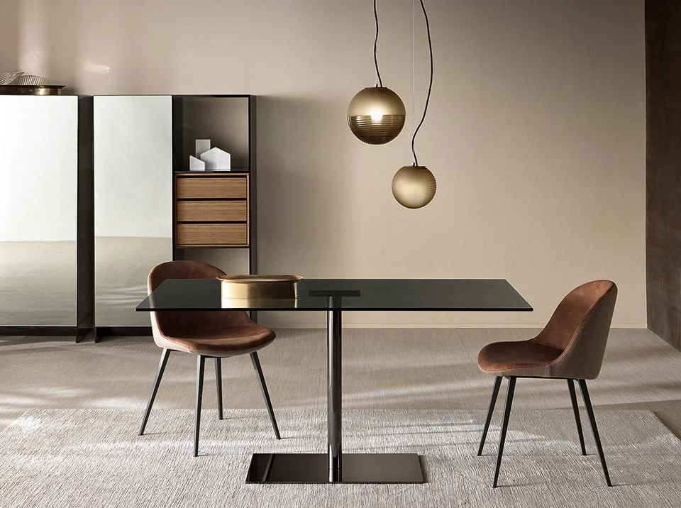 Farniente square dining table by Tonelli Design with extra-clear glass top and chromed metal base, displayed in Royal Oak, Michigan.
