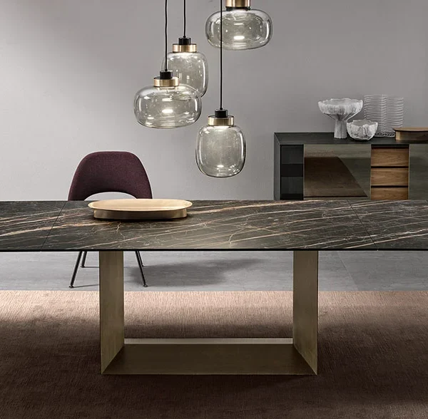 T5 E extendable dining table by Tonelli Design with central base in brushed bronze finish, top and extensions in polished Calacatta oro venato ceramic, displayed in Royal Oak, Michigan.